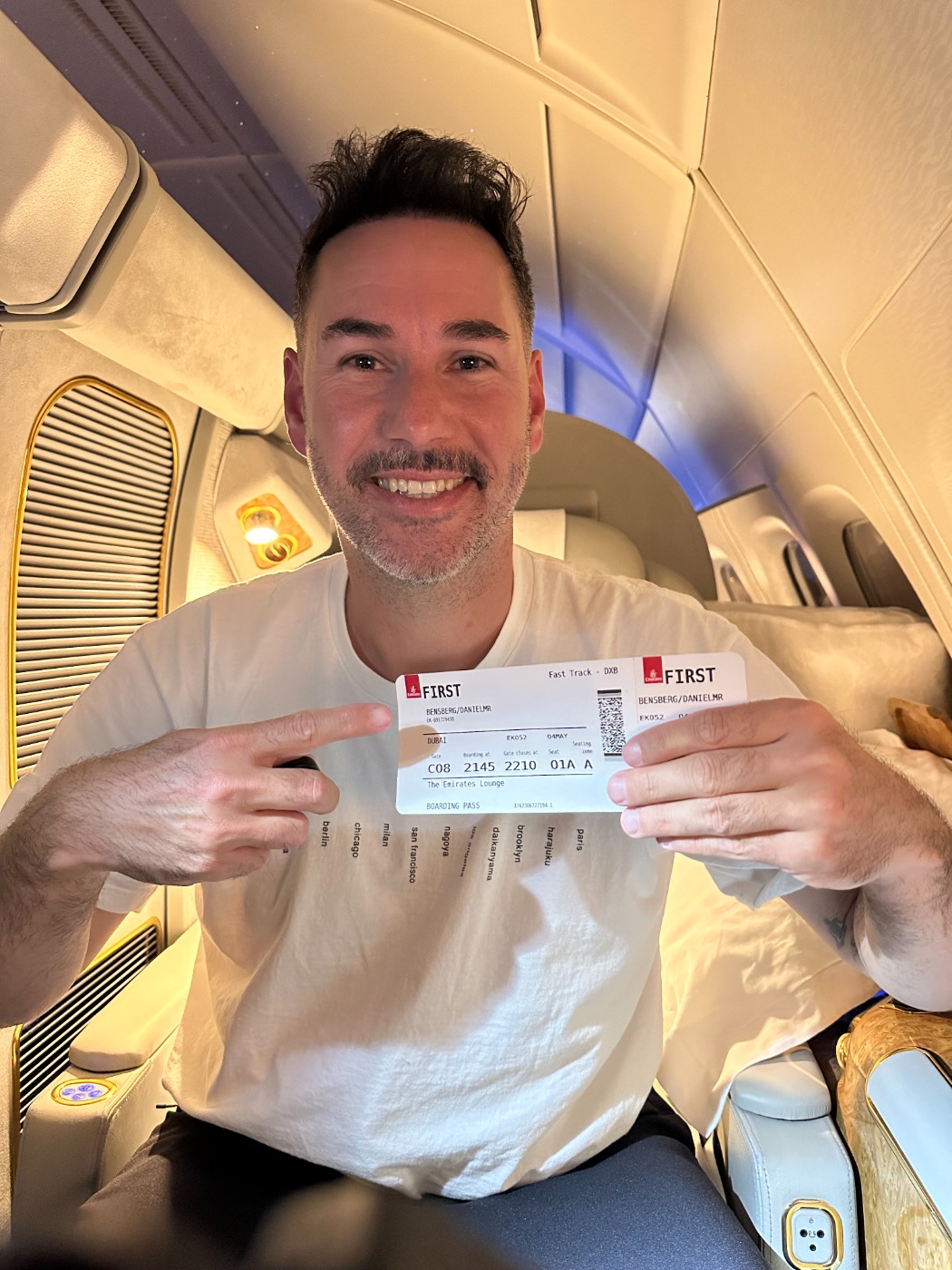 Daniel von Scale Up Your Card in der First Class mit seinem Ticket in der Hand